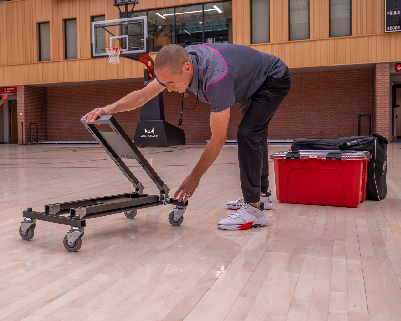 A coach disassembles a Monorack in front of his pile of training gear.